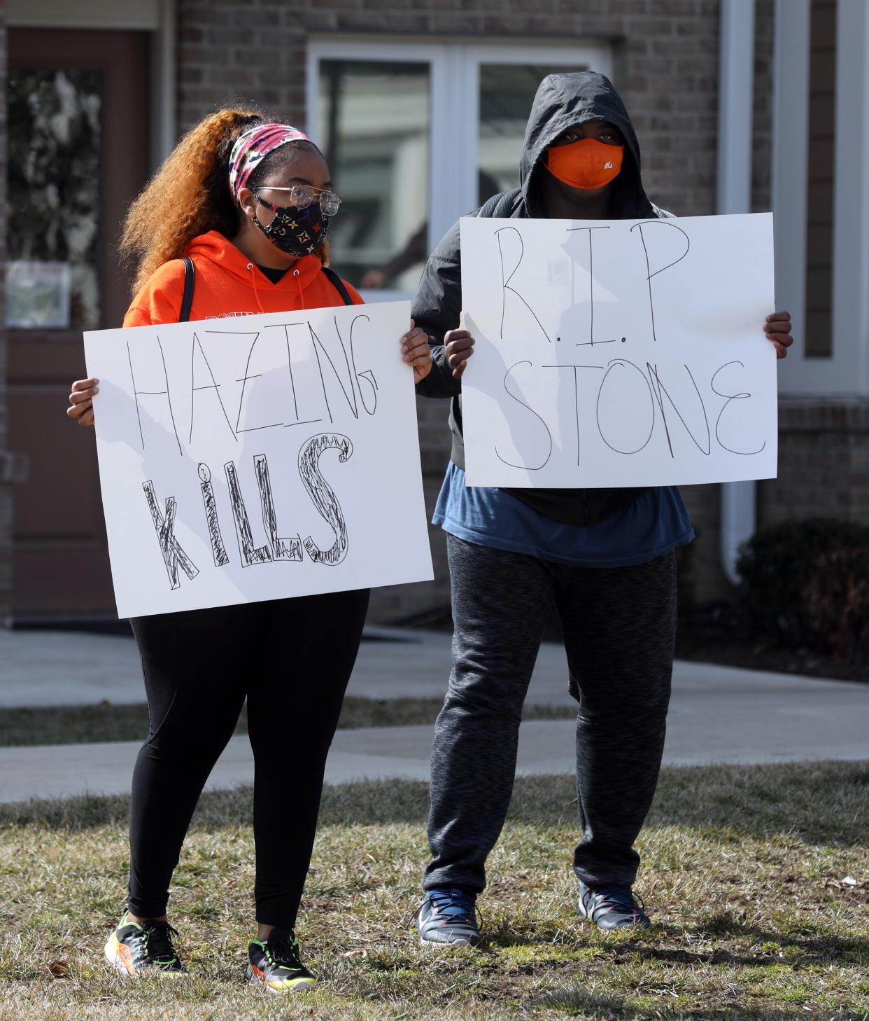 BGSU students hold signs near the Pi Kappa Alpha fraternity house at Bowling Green State University during a protest on Tuesday, March 9, 2021.
