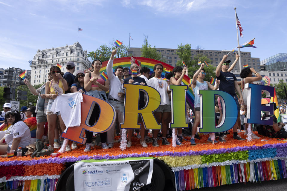 Participants of the Capital Pride Parade wave from a float during the annual celebrations of the LGBTQ+ community and supporters in Washington, Saturday, June 8, 2024. (AP Photo/Manuel Balce Ceneta)