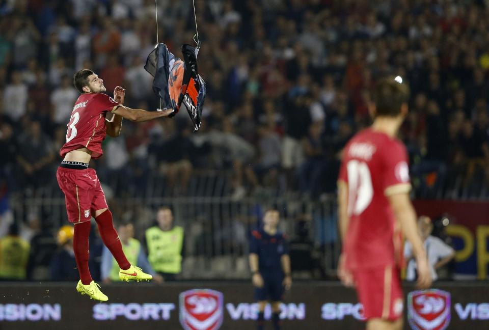 Stefan Mitrovic of Serbia grabs a flag depicting so-called Greater Albania, an area covering all parts of the Balkans where ethnic Albanians live, that was flown over the pitch during their Euro 2016 Group I qualifying soccer match against Albania at the FK Partizan stadium in Belgrade in this October 14, 2014 file photo. REUTERS/Marko Djurica/Files (SERBIA - Tags: SPORT SOCCER TPX IMAGES OF THE DAY)