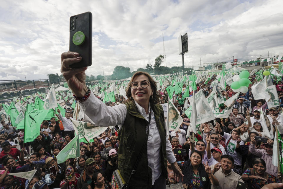 FILE - Fformer first lady Sandra Torres, the National Unity of Hope, UNE, presidential candidate, takes a selfie backdropped with supporters, during a campaign rally in Chimaltenango, Guatemala, Aug. 13, 2023. Torres will face Bernardo Arévalo of the Seed Movement party in the Sunday, Aug. 20 runoff election. (AP Photo/Moises Castillo, File)