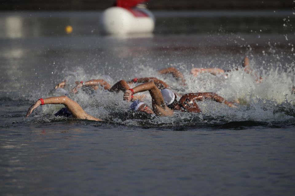 FILE - In this Aug. 11, 2019, file photo, athletes compete in a marathon swimming test event at Odaiba Marine Park, a venue for marathon swimming and triathlon at the Tokyo 2020 Olympics, in Tokyo. The IOC moved next year’s Tokyo Olympic marathons and race walks out of the Japanese capital to avoid the stifling heat and humidity. Some swimmers and an 11,000-member coaching body want similar treatment: find an alternative to the distance-swimming venue in Tokyo Bay known as the “Odaiba Marine Park.”(AP Photo/Jae C. Hong, File)