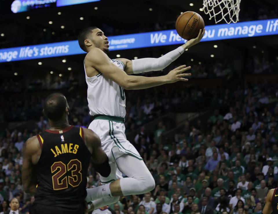 Celtics forward Jayson Tatum goes by LeBron James to the basket during the fourth quarter Wednesday night. (AP)