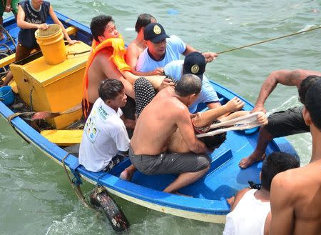 Rescuers carry the body of a dead victim following the capsize of a ferry, at a port in Ormoc city, central Philippines July 2, 2015. REUTERS/Ronald Frank Dejon