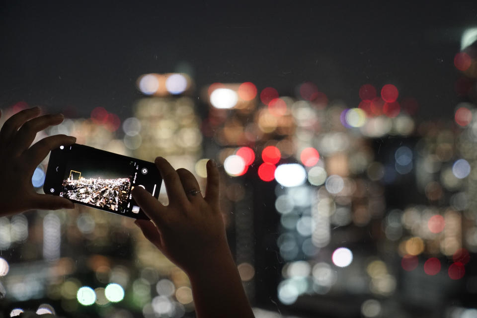 A tourist uses her smartphone to photograph Tokyo's skyline from the Seaside Top observatory located on the 40th floor of the World Trade Center Building, Wednesday, Sept. 25, 2019, in Tokyo. (AP Photo/Jae C. Hong)