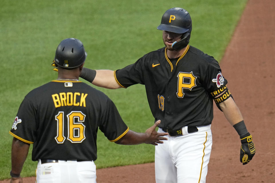 Pittsburgh Pirates' Jared Triolo, right, celebrates with first base coach Tarrik Brock (16) after driving in two runs with a single off Atlanta Braves starting pitcher Spencer Strider during the third inning of a baseball game in Pittsburgh, Monday, Aug. 7, 2023. (AP Photo/Gene J. Puskar)