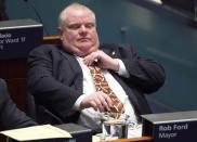 Toronto Mayor Rob Ford adjusts his tie with footballs printed on it at City Hall in Toronto, November 14, 2013. Embattled mayor Ford, under huge pressure to quit after he admitted smoking crack cocaine, said on Thursday he was getting help for a drinking problem, but offered no indication that he might step down. Ford also expressed remorse for an obscene outburst he made earlier in the day when denying an allegation he had made sexual overtures to a female member of his staff. REUTERS/Mark Blinch (CANADA - Tags: POLITICS CRIME LAW)