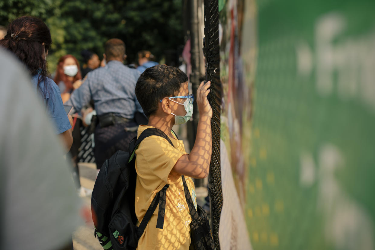 Un estudiante mira a través de una valla en una escuela del barrio Harlem del Este de Manhattan, el 6 de julio de 2021. (Jose A. Alvarado Jr./The New York Times)