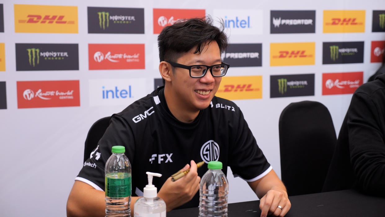 TSM's MoonMeander smiles while holding a marker seated behind a table