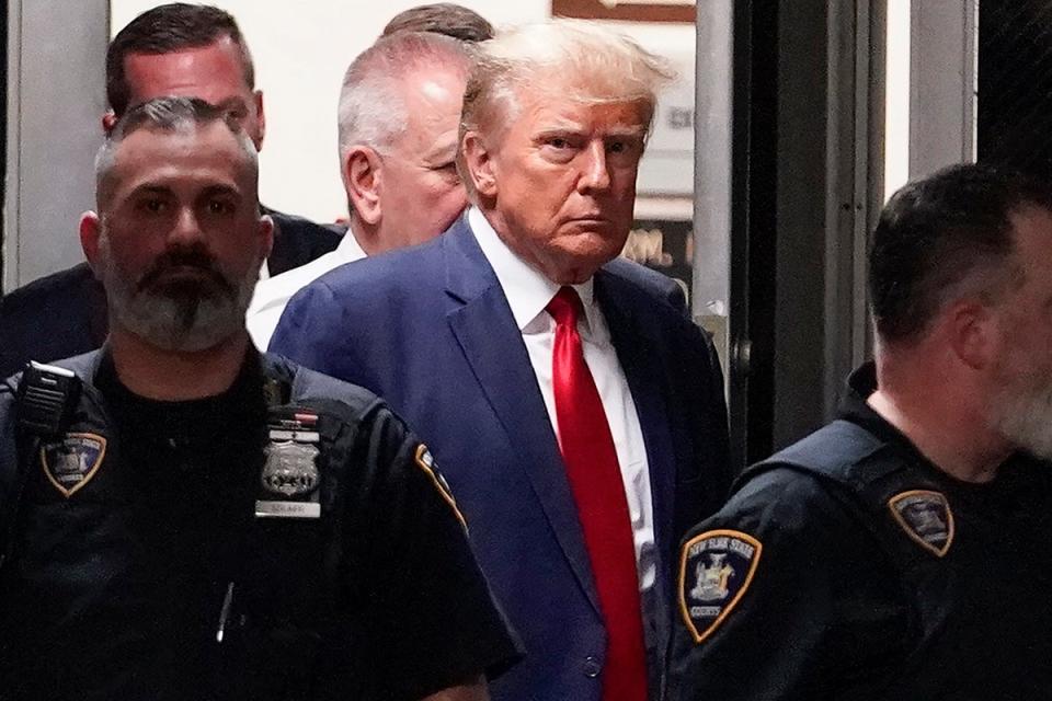 El expresidente Donald Trump es escoltado a una sala del tribunal de Nueva York el 4 de abril de 2023 para responder a la acusación estatal que le acusa de falsificar registros comerciales para tapar un soborno que pagó a la actriz porno Stormy Daniels (Mary Altaffer/AP)