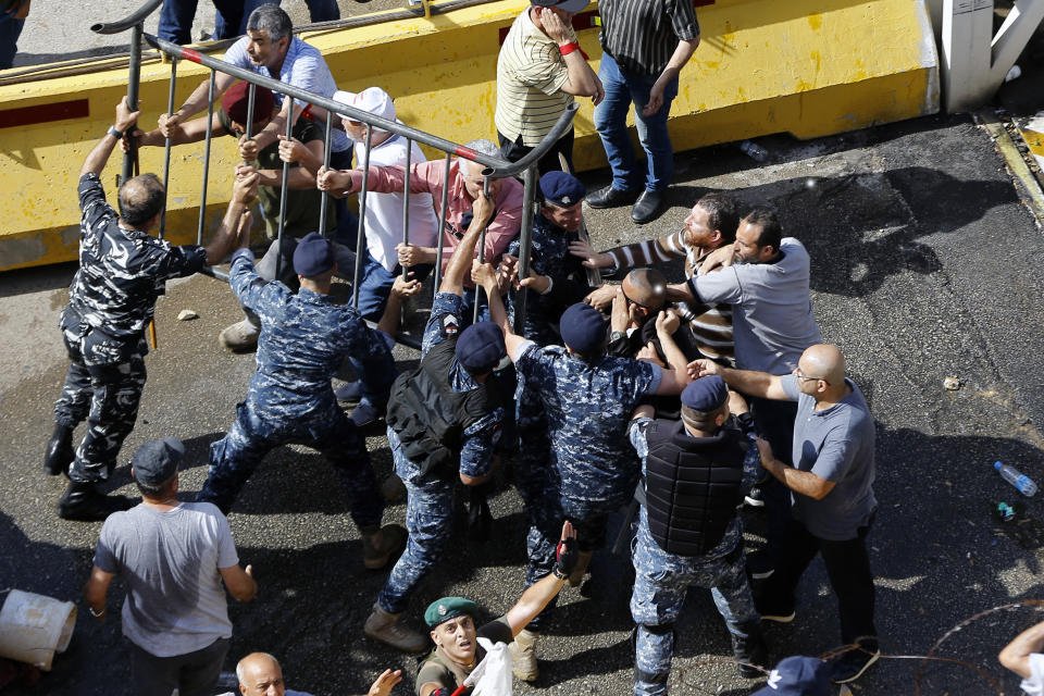 Security forces clash with retired army officers as they try to advance toward the Government House in Beirut, Lebanon, Monday, May 20, 2019. Over one hundred protesters gathered Monday in downtown Beirut shouting "Thieves, thieves!" as the Cabinet met for its 16th session to reach agreement on controversial budget cuts. (AP Photo/Bilal Hussein)