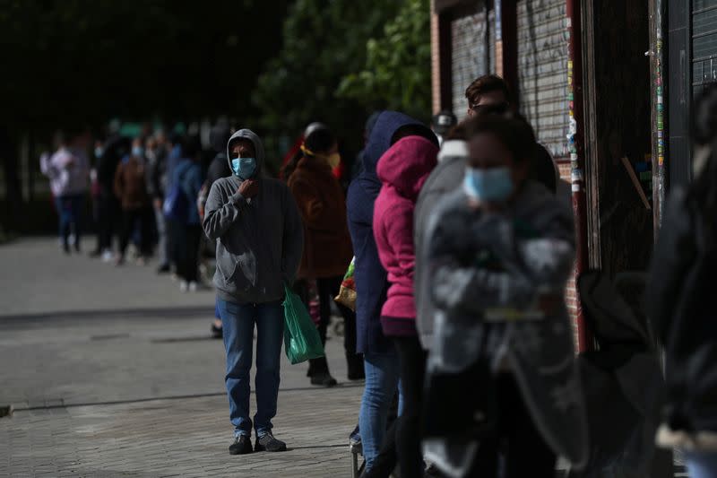 People queue to receive donated food from volunteers of Vecinos Parque Aluche association as the spread of the coronavirus disease (COVID-19) continues in Madrid