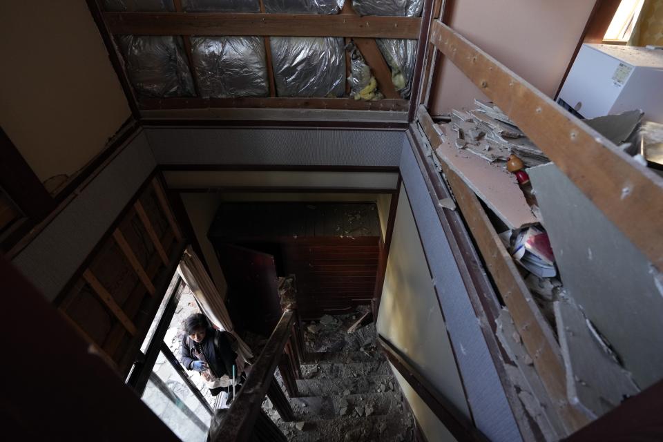 A person looks at a damaged house caused by powerful earthquake Tuesday, Jan. 2, 2024, near Anamizu town, Ishikawa Prefecture, Japan. (AP Photo/Hiro Komae)