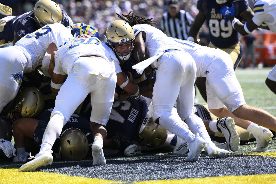 Navy quarterback Tai Lavatai, center, dives for a touchdown during the second half of an NCAA college football game against Delaware, Saturday, Sept. 3, 2022, in Annapolis, Md. Delaware won 14-7. (AP Photo/Nick Wass)