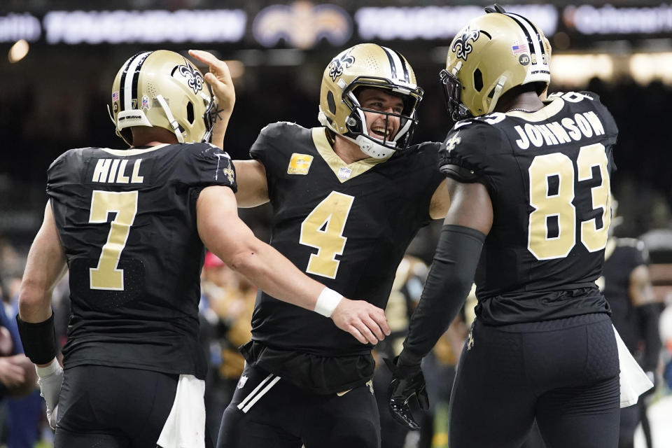 New Orleans Saints' Taysom Hill (7) celebrates his touchdown catch with quarterback Derek Carr (4), and tight end Juwan Johnson (83) during the first half of an NFL football game against the Chicago Bears in New Orleans, Sunday, Nov. 5, 2023. (AP Photo/Gerald Herbert)