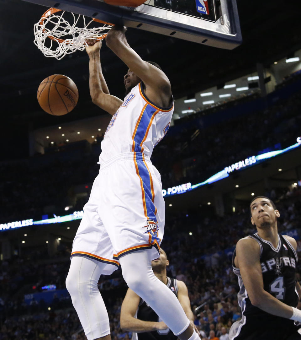 Oklahoma City Thunder forward Kevin Durant (35) dunks in front of San Antonio Spurs guard Tony Parker and guard Danny Green (4) in the second quarter of an NBA basketball game in Oklahoma City, Thursday, April 3, 2014. (AP Photo/Sue Ogrocki)