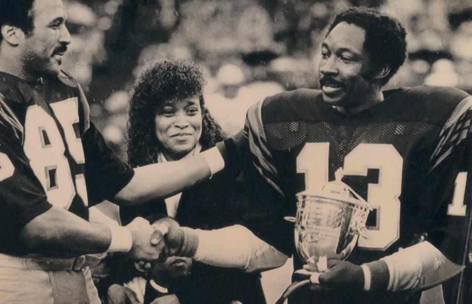 Cincinnati Bengals cornerback Ken Riley, right, is congratulated by teammate Isaac Curtis during ceremonies at halftime Sunday, Dec. 12, 1983, during Riley's 15th and final season.