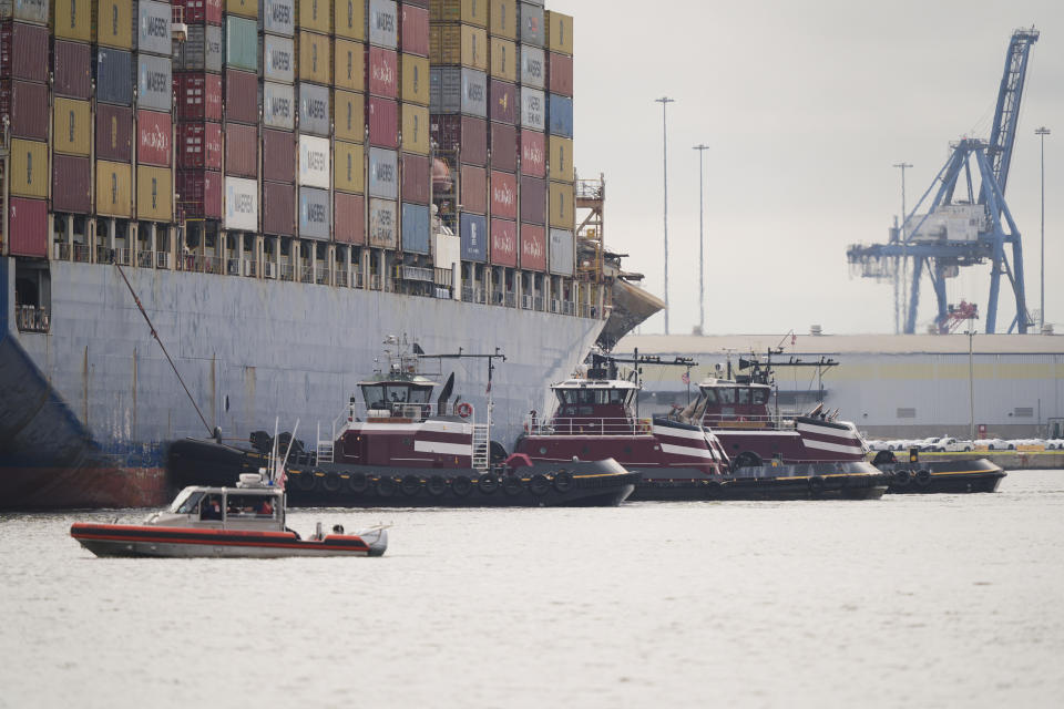 Tugboats escort the container ship Dali after it was refloated in Baltimore, Monday, May 20, 2024. The recovery from the deadly Baltimore bridge collapse reached a significant milestone Monday as the ill-fated container ship Dali was slowly escorted back to port, its damaged bow still covered with smashed shipping containers, fallen steel trusses and mangled concrete. (AP Photo/Matt Rourke)