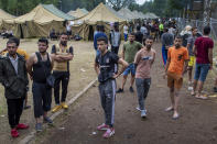 Migrants walk inside the newly built refugee camp in the Rudninkai military training ground, some 38km (23,6 miles) south from Vilnius, Lithuania, Wednesday, Aug. 4, 2021. The Red Cross warned Wednesday that Lithuania's decision to turn away immigrants attempting to cross in from neighboring Belarus does not comply with international law. Lithuania, a member of the European Union, has faced a surge of mostly Iraqi migrants in the past few months. Some 4,090 migrants, most of them from Iraq, have crossed this year from Belarus into Lithuania. (AP Photo/Mindaugas Kulbis)