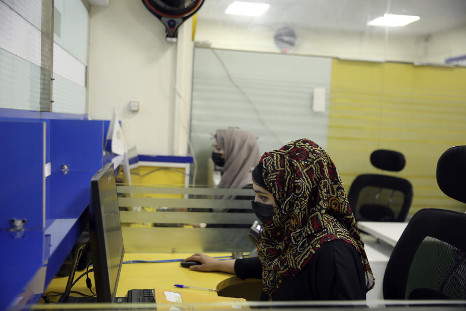 Female workers sit in front of computer in their office in the city of Kabul, Afghanistan, Wednesday, July 3, 2024. In parts of Afghanistan where there are no street names or house numbers, utility companies and their customers have adopted a creative approach for connecting. They use mosques as drop points for bills and cash, a "pay and pray" system. (AP Photo/Siddiqullah Alizai)