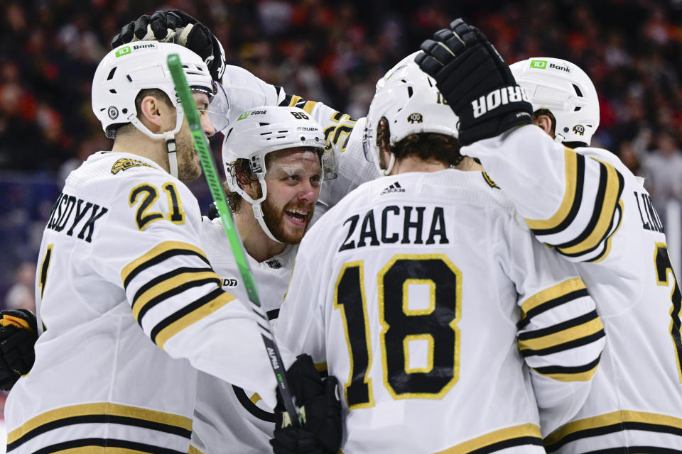 Boston Bruins' David Pastrnak, second from left, celebrates with teammates after scoring a goal during the first period of an NHL hockey game against the Philadelphia Flyers, Saturday, Jan. 27, 2024, in Philadelphia. (AP Photo/Derik Hamilton)