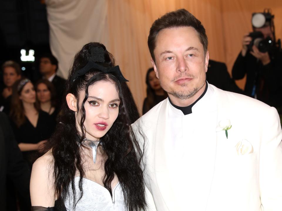 Grimes and Elon Musk pose together on the red carpet.