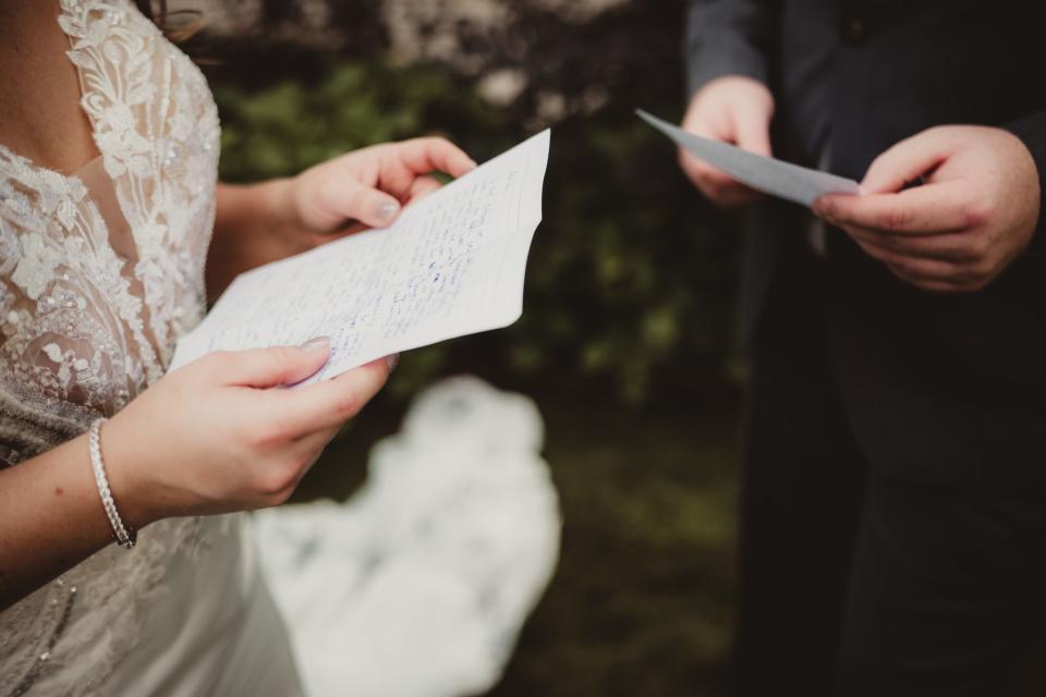 <p>Getty</p> Stock image of bride and groom reading wedding vows