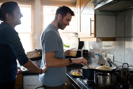 Adi, 37, who works for a removal company, and his wife Maria, 31, cook together at their home in London, Britain, February 22, 2019. REUTERS/Alecsandra Dragoi