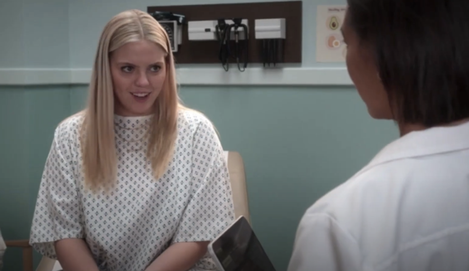 Two women in conversation, one is a patient wearing a hospital gown, and the other appears to be a medical professional