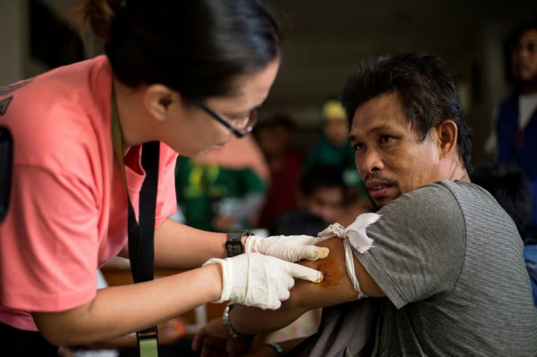 A volunteer doctor tends to a man that was trapped for 11 days in Marawi City