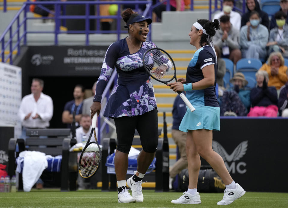 Serena Williams of the United States, left, and Ons Jabeur of Tunisia celebrate after wining their doubles tennis match against Marie Bouzkova of Czech Republic and Sara Sorribes Tormo of Spain at the Eastbourne International tennis tournament in Eastbourne, England, Tuesday, June 21, 2022. (AP Photo/Kirsty Wigglesworth)