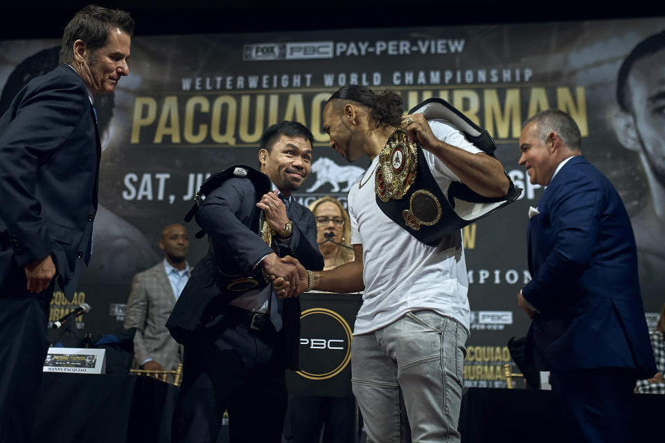 Manny Pacquiao, center left, shakes hands with Keith Thurman, center right, during a news conference Tuesday, May 21, 2019, in New York. The two are scheduled to fight in a welterweight world championship bout on Saturday, July 20, in Las Vegas. (AP Photo/Andres Kudacki)