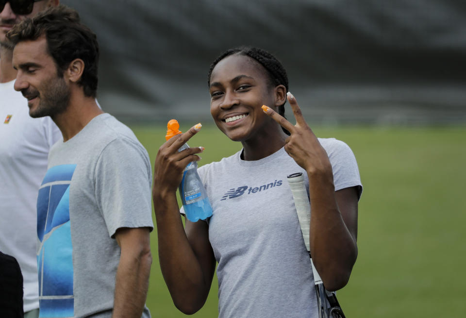 United States' Cori Gauff gestures to photographers during a practice session ahead of the Wimbledon Tennis Championships in London Sunday, June 30, 2019. (AP Photo/Ben Curtis)