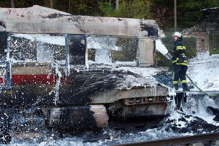 Firefighters work at a destroyed German high speed ICE train after it caught fire on the way from Cologne to Frankfurt in Dierdorf, Germany, October 12, 2018. REUTERS/Wolfgang Rattay