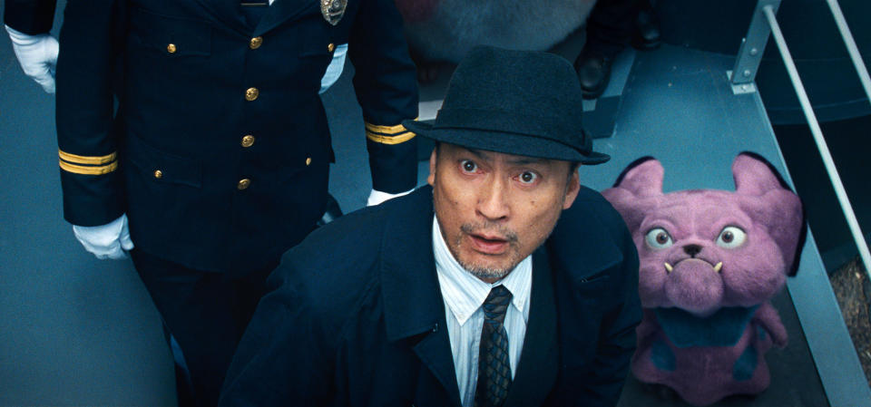 This image released by Warner Bros. Pictures shows Ken Watanabe and the character Snubbull in a scene from "Pokemon Detective Pikachu." (Warner Bros. Pictures via AP)