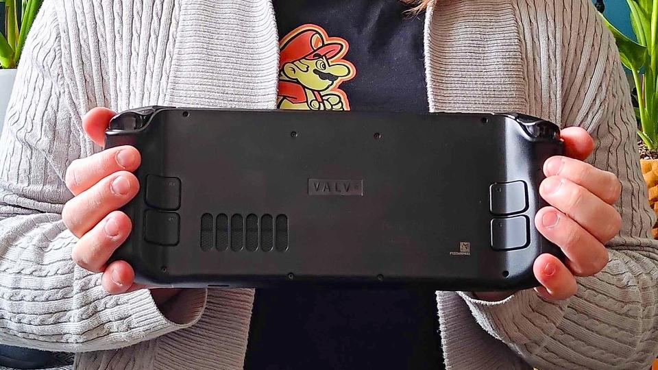 Phil Hayton holding Steam Deck with back of handheld facing forward