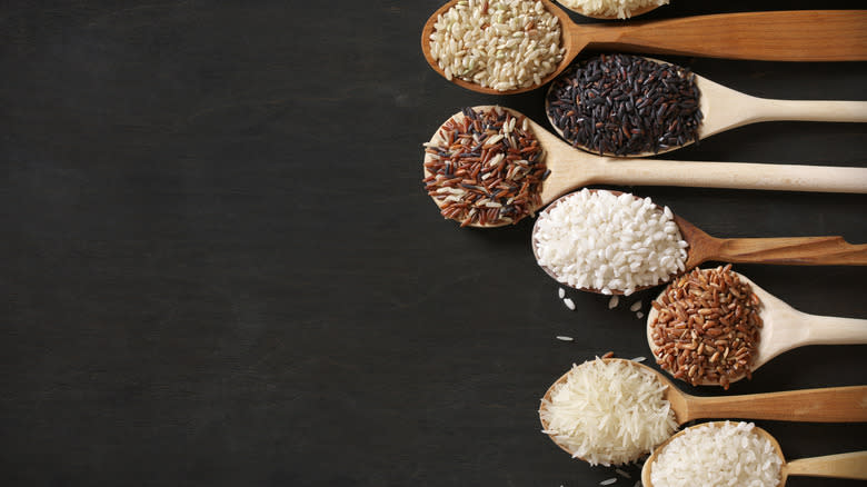 different types of rice displayed in wooden spoons