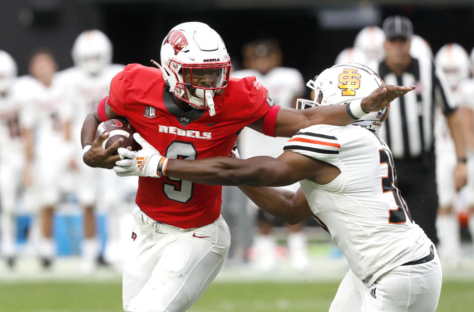 UNLV running back Aidan Robbins (9) tries to fend off a tackle by Idaho State linebacker Charles Ike (30) during the first half of an NCAA college football game at Allegiant Stadium, Saturday, Aug. 27, 2022, in Las Vegas. (Steve Marcus/Las Vegas Sun via AP)