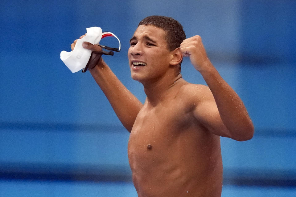 Ahmed Hafnaoui, of Tunisia, celebrates after winning the final of the men's 400-meter freestyle at the 2020 Summer Olympics, Sunday, July 25, 2021, in Tokyo, Japan. (AP Photo/Charlie Riedel)