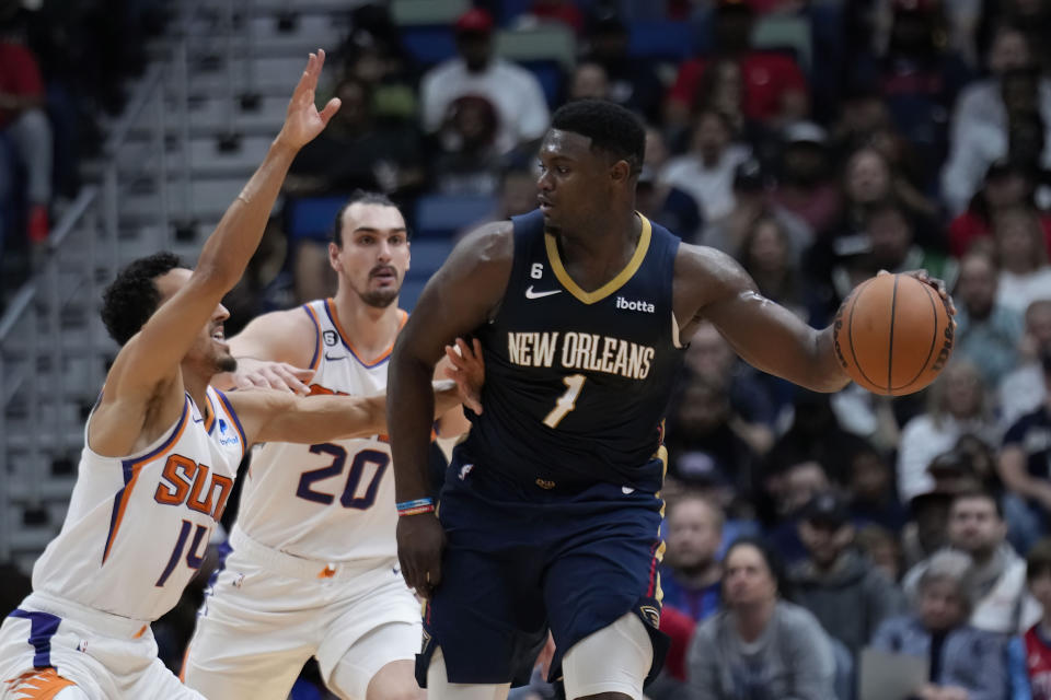 New Orleans Pelicans forward Zion Williamson (1) looks to pass around Phoenix Suns guard Landry Shamet (14) in the first half of an NBA basketball game in New Orleans, Sunday, Dec. 11, 2022. (AP Photo/Gerald Herbert)