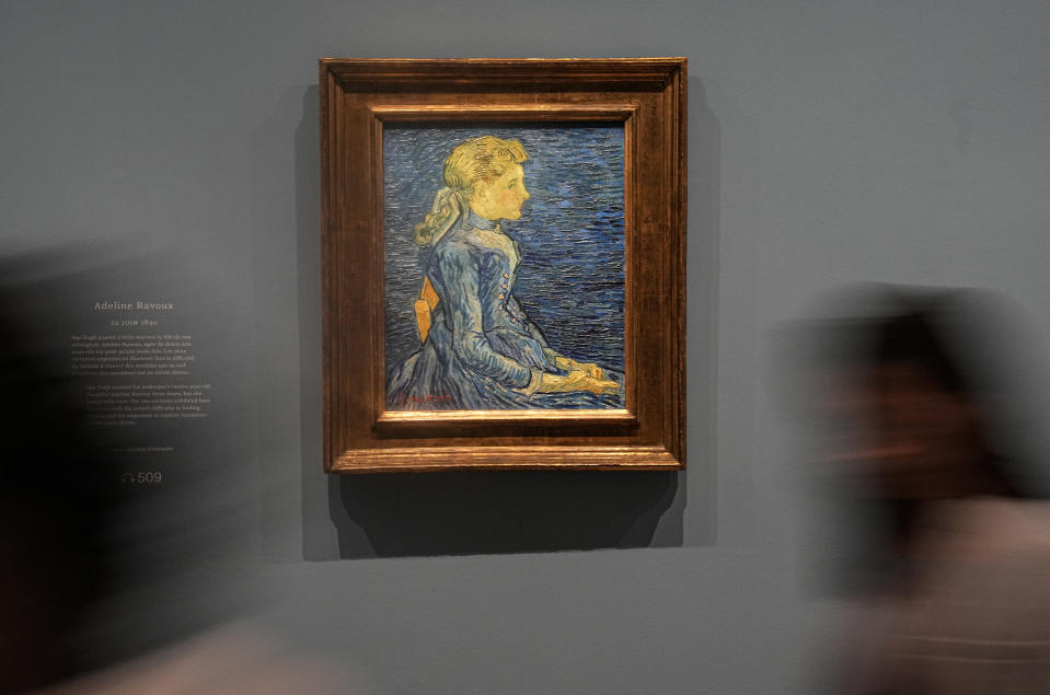 People walk past Vincent Van Gogh's oil on canvas painting "Adeline Ravoux", painted on June 22, 1890, during the press day at the "Van Gogh in Auvers-sur-Oise: The Final Months" exhibition at the Musee d'Orsay in Paris, Friday, Sept. 29, 2023. The exhibition opens for the public from Oct. 3, 2023 to Feb. 4, 2024. The new Van Gogh exhibition concentrated on the two months before his death at age 37 on July 29, 1890, is both extraordinary and extraordinarily painful — because this brief period was one of the artist's most productive but was also his last. (AP Photo/Michel Euler)