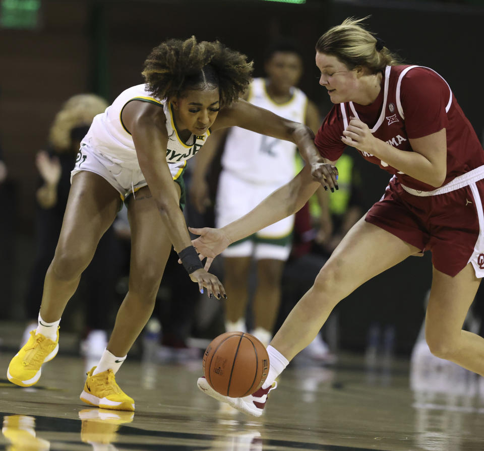 Baylor guard DiDi Richards, left, reaches for the ball over Oklahoma forward Mandy Simpson, right, in the first half of an NCAA college basketball game, Saturday, Jan. 23, 2021, in Waco, Texas. (Rod Aydelotte/Waco Tribune-Herald via AP)