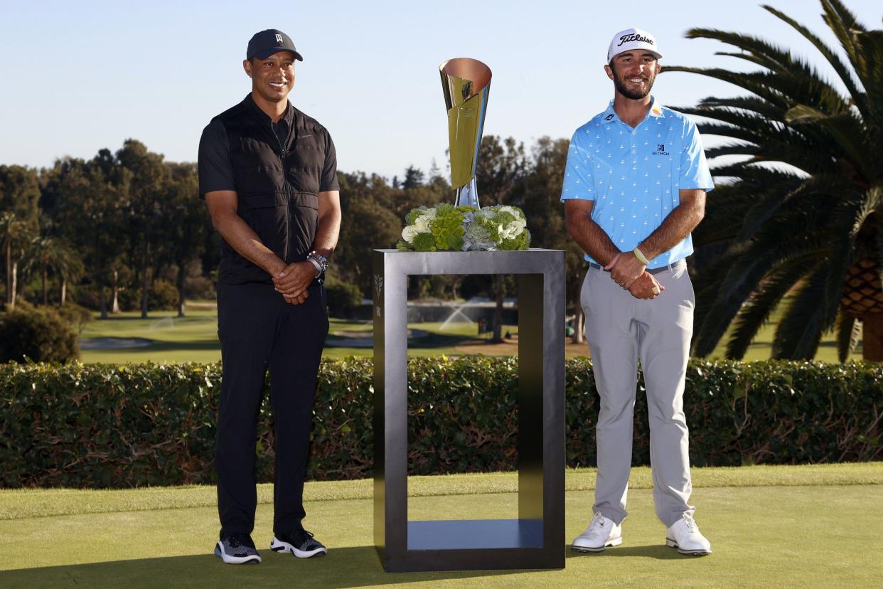 Max Homa, right, poses with his trophy next to Tiger Woods on the practice green after winning the Genesis Invitational golf tournament Sunday at Riviera Country Club in Los Angeles. 