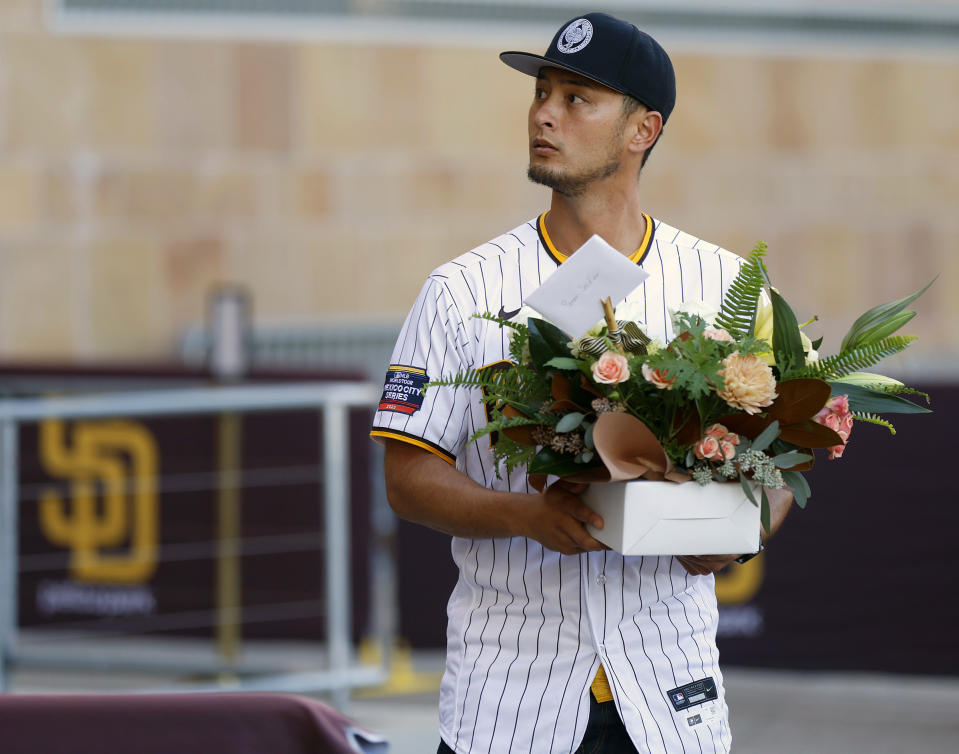 San Diego Padres pitcher Yu Darvish walks up to lay flowers at a public memorial Tuesday, Nov. 14, 2023, on the steps of Petco Park in San Diego for Padres owner Peter Seidler, who passed away earlier in the day. (K.C. Alfred/The San Diego Union-Tribune via AP)