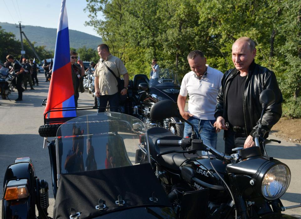 Russian President Vladimir Putin, right, looks at a Russia made "Ural" motorbike during the Babylon's Shadow bike show camp near in Sevastopol, Crimea, Saturday, Aug. 10, 2019. (Alexei Druzhinin, Sputnik, Kremlin Pool Photo via AP)