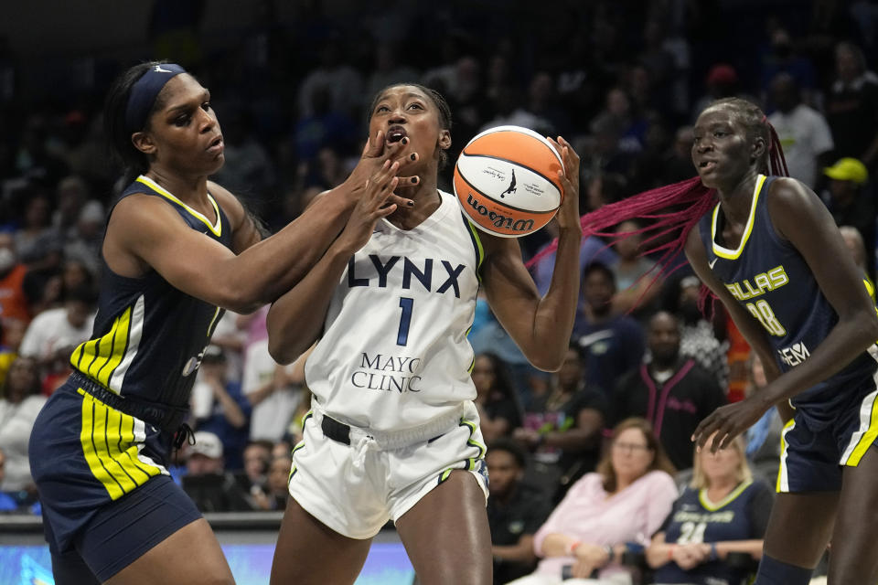 Minnesota Lynx guard Diamond Miller (1) works to the basket for a shot against Dallas Wings center Teaira McCowan, left, and Awak Kuier (28) in the second half of a WNBA basketball game, Thursday, Aug. 24, 2023, in Arlington, Texas. (AP Photo/Tony Gutierrez)