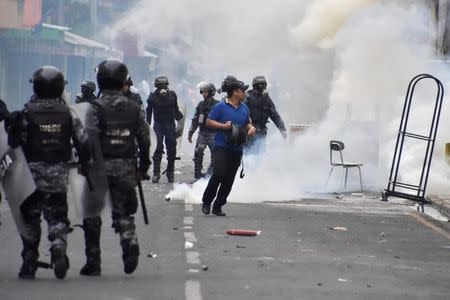 A man walks away from tear gas as supporters of Salvador Nasralla, presidential candidate for the Opposition Alliance Against the Dictatorship, clash with police during a protest caused by the delayed vote count for the presidential election in San Pedro Sula, Honduras December 1, 2017. REUTERS/Moises Ayala
