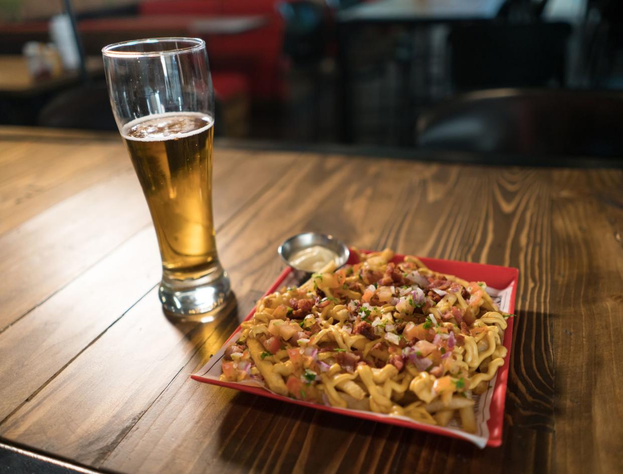 Close-up on a plate of macaroni and cheese served at the bar with beer - food and drinks concepts