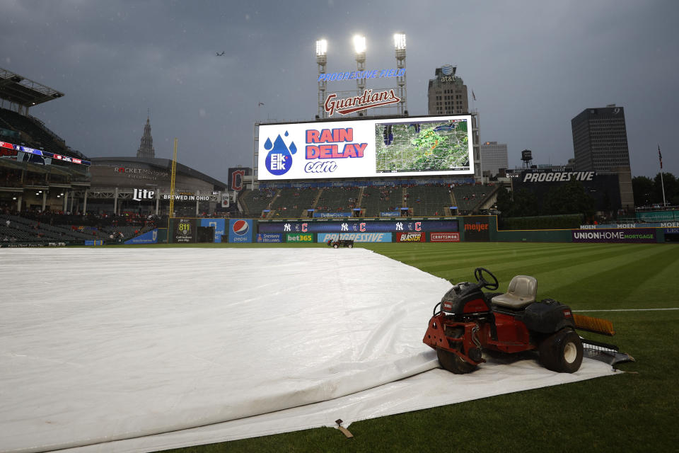 The tarp covers the infield before a scheduled baseball game between the New York Yankees and the Cleveland Guardians on Friday, July 1, 2022, in Cleveland. (AP Photo/Ron Schwane)