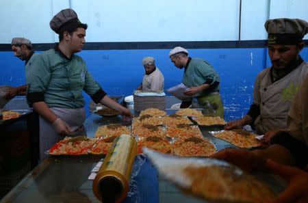 Workers of Adaleh Foundation prepare food at their soup kitchen during the holy month of Ramadan in the rebel-held besieged town of Douma to the east of Damascus, Syria June 20, 2017. REUTERS/Bassam Khabieh SEARCH "IFTAR ADALEH" FOR THIS STORY. SEARCH "WIDER IMAGE" FOR ALL STORIES.