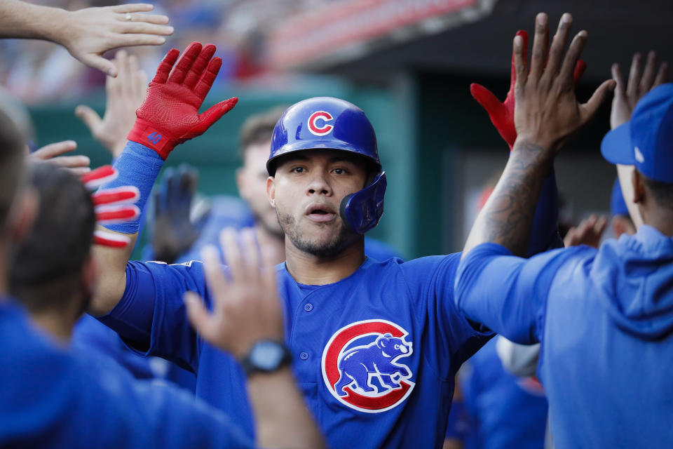 Chicago Cubs' Willson Contreras is congratulated in the dugout after hitting an RBI sacrifice fly off Cincinnati Reds starting pitcher Tanner Roark during the fifth inning of a baseball game Tuesday, May 14, 2019, in Cincinnati. (AP Photo/John Minchillo)